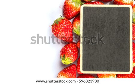 Ripe strawberry fruits with mini blank blackboard over white background