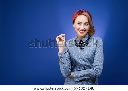 Portrait of funny emotional girl in pinup style on blue background