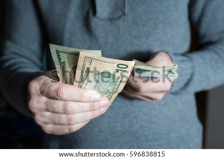 Man giving us dollar banknote and holding cash in hands. Money credit concept