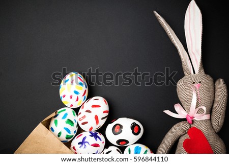 Easter bunny in a paper bag. Rabbit. Black background. Easter ideas. Easter eggs. Space for text.