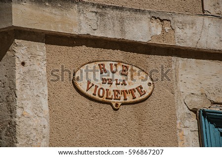 Close-up of street sign board with sunny blue sky in the city center of Nimes. Located in the Gard department, Occitanie region in southern France