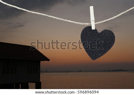 Black Heart hung on hemp rope on view sunset background and have copy space to manage the text you want.