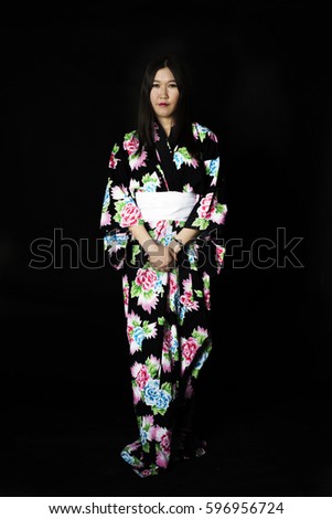 Japanese girl in traditional Japanese kimono on black background. Isolated photo.