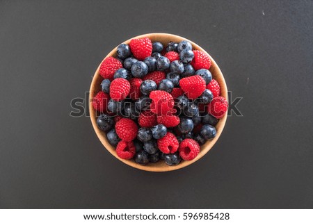 fresh blueberry and rasberry on wood bowl