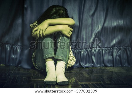 Child lonely alone in an empty room Royalty-Free Stock Photo #597002399