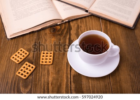 Cup of tea on wooden table with biscuit cookies
