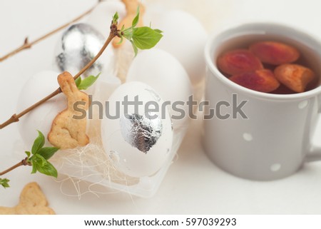 Easter breakfast with eggs, cookie spring greenery and stewed fruit on a white background.