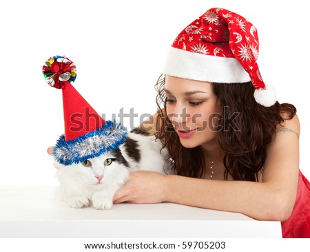 Beautiful girl with a cat in New Year's caps. In the Oriental calendar 2011 - the year of cat.