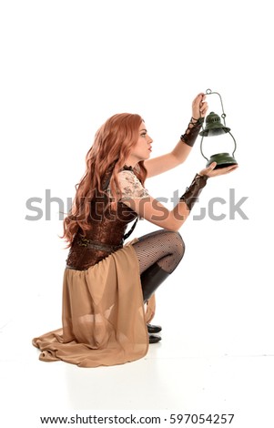 full length portrait of a beautiful girl wearing steampunk outfit, kneeling pose isolated on white background.