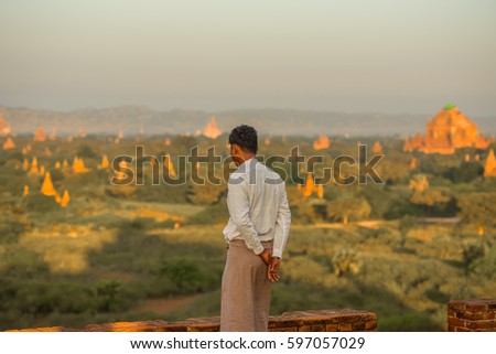 Man watching sunrise over historic Buddhist temples and stupas in Bagan, Myanmar
