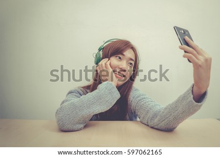 portrait of a woman with taking selfie using smart phone.vintage style