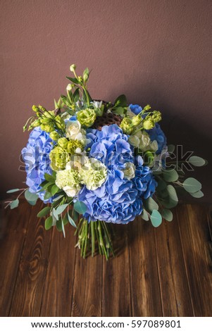 Luxury bouquet of hydrangea flowers with dry lotus. Bunch of fresh flowers on wooden background

