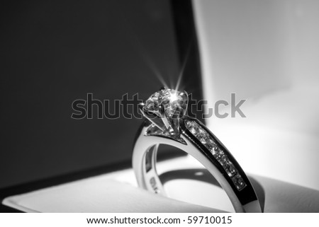 A diamond engagement ring in a box with glint/reflection. Royalty-Free Stock Photo #59710015