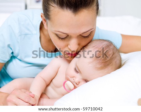 Portrait of a happy young mother near sleeping baby
