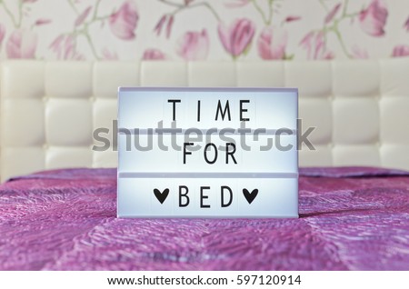 Time for bed sign shown in lightbox iin glamour pink bedroom interior