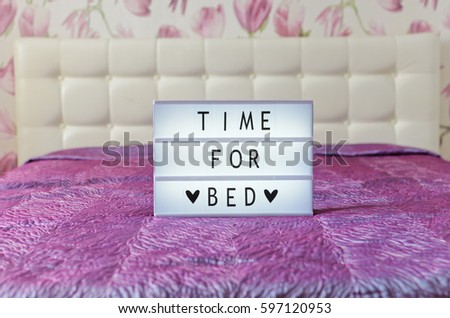 Time for bed sign shown in lightbox  in glamour pink bedroom interior