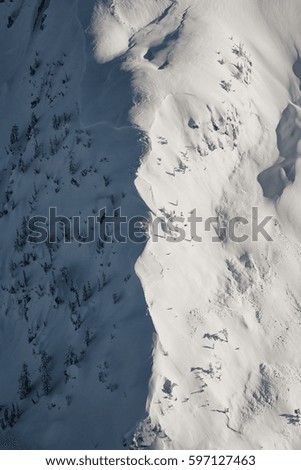 Abstract aerial landscape of the mountain hill covered with snow. Picture taken north of Vancouver during a sunny winter evening.