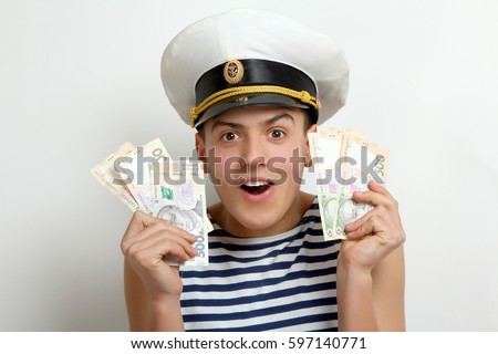 Young sailor holding money on white background