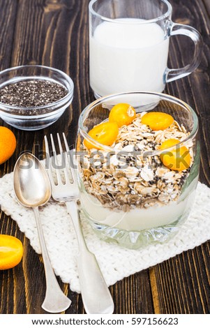 Healthy breakfast, oatmeal with kumquats, granola, yoghurt, chia seeds, milk. Studio Photo