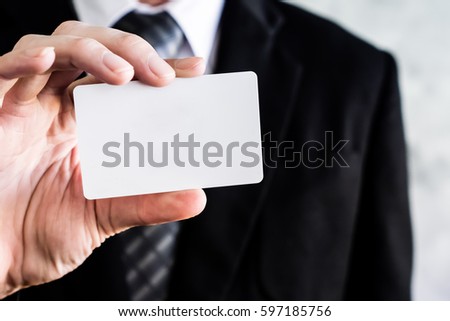 Close up of businessman holding white blank card.