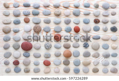pattern of colored pebbles on white wooden background. Flat lay, top view