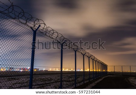 Fence with barbed wire, restricted area Royalty-Free Stock Photo #597231044
