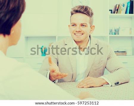 Young handsome man tells woman about interesting offers of his company