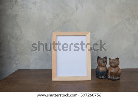 photo Frame and toy cat on a wooden on Gray wall background .