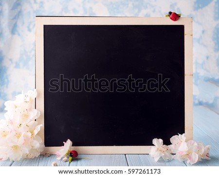 flowers with a chalk board for a place in the text on wooden sky background