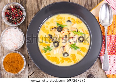 Vegetable soup puree with mussels in black plate on wooden background. Studio Photo