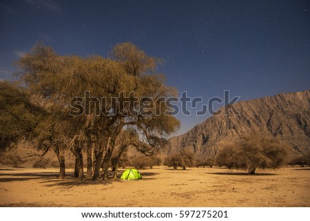 Wild camping in Musandam peninsula, Oman, Arabia, night photo with shining camping tent