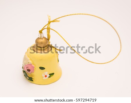ceramic ornamental yellow bell with a sheep and flowers on it and a golden ribbon