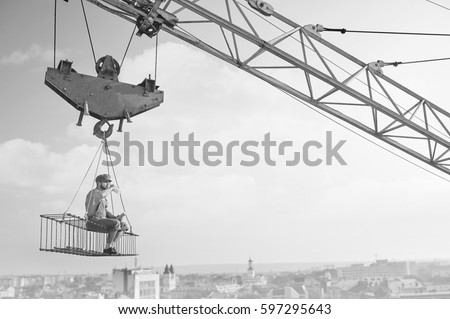 Vintage handyman having lunch on a crossbar hanging above the ci Royalty-Free Stock Photo #597295643
