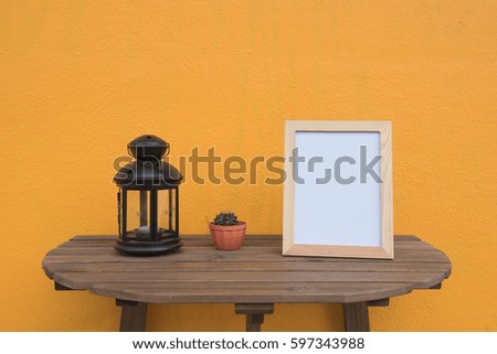 photo Frame and lamp , cactus on a wooden on Yellow background .