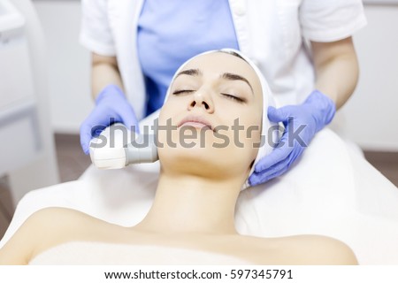 Skin care. Young woman receiving facial beauty treatment, Intense pulsed light therapy. Photo facial therapy. Anti-aging procedures.