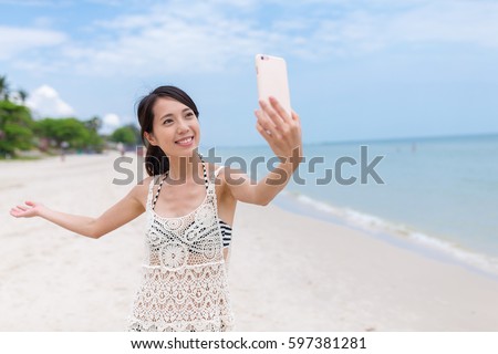 Woman taking selfie by mobile phone in beach