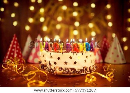 Happy birthday cake with candles on the background of garlands a