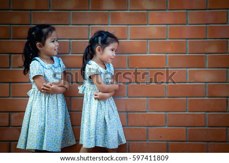 Asia little girl standing with brick wall