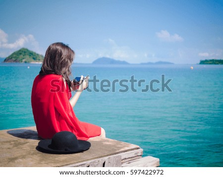 Asian girl sitting on bridge.she look relaxing with beautiful view of Thailand sea:Travel and Vacation concept