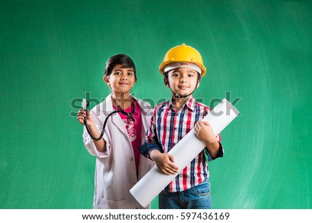 Kids and education concept - Small indian boy and girl posing in front of Green chalk board in engineers fancy dress and doctor costume with stethoscope Royalty-Free Stock Photo #597436169