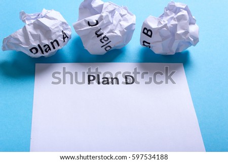 Crumpled paper Plan A B C and clean sheet Plan D on a blue background