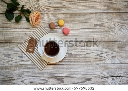 Coffee, cake macaron and flower on white table.  Cozy breakfast. 