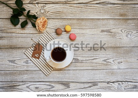 Delicious colorful macarons and coffee cup. Coffee break scene.
