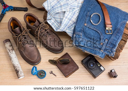 Men's casual outfits and vacation items for traveler on wood background