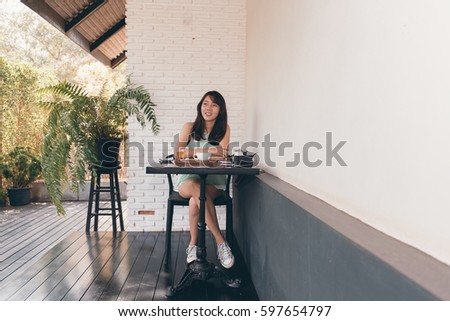 Enjoyment - free happy woman enjoying.Young hipster girl with vintage camera in coffee shop