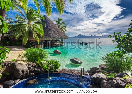 Large outdoor jacuzzi and infinity pool over tropical ocean, Tahiti resort Royalty-Free Stock Photo #597655364