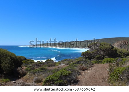 Scenic view from the lookout at Sugar Loaf Rock, South Western Australia in the blue Indian Ocean a popular fishing and hiking destination with its treeless green  dunes and  splashing waves .