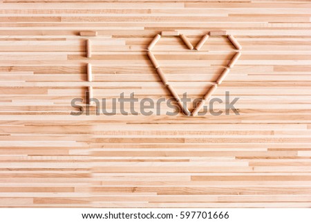 Heart composed of wooden dowels on wooden background. Do it yourself needs. Home Improvement Store. Joinery and carpentry needs. Background with heart. I love you.  Wooden sign and symbol of love.