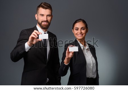 Business partners demonstrate visit cards. Horizontal photo of two companions in formal clothing. Blank cards with copy space for inserting your own text or a picture.