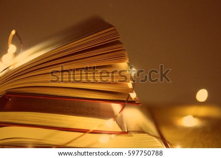 Book and shining garlands on the plank wooden table